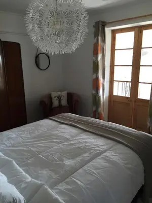 a bedroom with a large white bed and a chandelier at Bay View Cottage - Amazing sea views and 3 bedrooms Sleeps 6-8 in Treknow