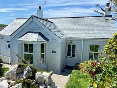 a white cottage with a front door and windows at Bay View Cottage - Amazing sea views and 3 bedrooms Sleeps 6-8 in Treknow