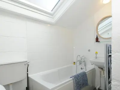 a bathroom with a white tub and a sink at Little Ruffo in Tintagel