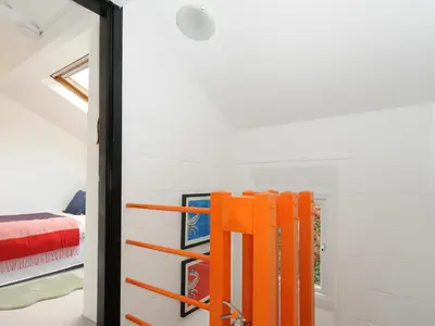 an open door to a bedroom with orange furniture at Little Ruffo in Tintagel