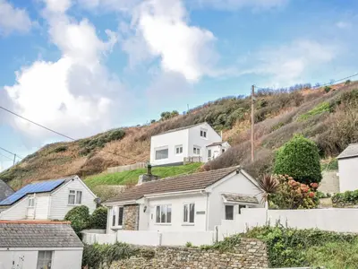 a white house on the side of a hill at Little Ruffo in Tintagel