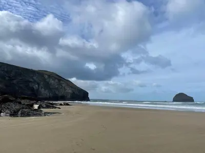 a beach with rocks and the ocean on a cloudy day at Little Ruffo in Tintagel