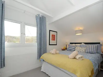 a bedroom with a bed and a window at Little Ruffo in Tintagel