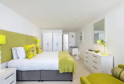 a bedroom with a large bed with yellow pillows at 25 Rocklands in Newquay in Newquay