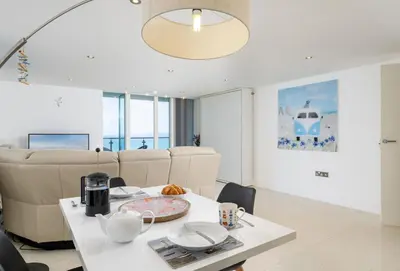 a living room with a white table and couch at 25 Rocklands in Newquay in Newquay