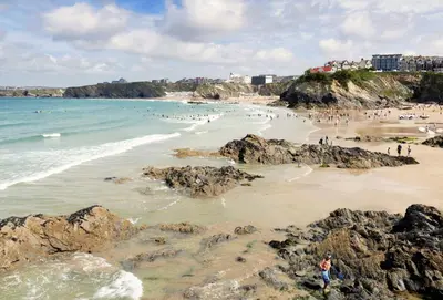 a group of people on a beach with rocks at Cinq 5 Zinc in Fistral, Newquay in Newquay