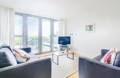 a living room with two couches and a television at Cinq 5 Zinc in Fistral, Newquay in Newquay