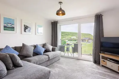 a living room with a couch and a tv at Sandcastles 11 Europa Court in Mawgan Porth in Mawgan Porth