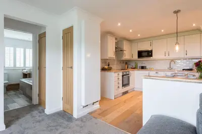 a kitchen with white cabinets and a counter top at Sandcastles 11 Europa Court in Mawgan Porth in Mawgan Porth