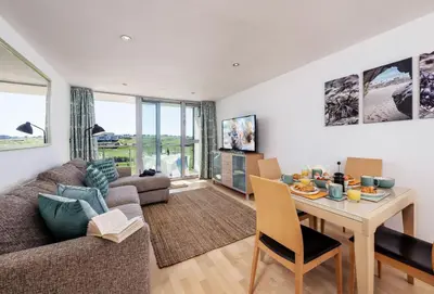 a living room with a couch and a table at Surfside 34 Zinc in Newquay in Newquay