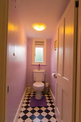 a small bathroom with a toilet and a window at Lamledra Farm House Apartment in Gorran Haven