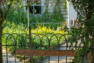 a sign on a fence in a garden at Lamledra Farm House Apartment in Gorran Haven