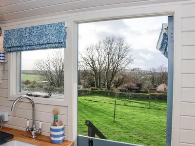 a kitchen window with a view of a yard at Teg in Helston