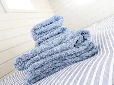 a blue towel sitting on top of a bed at Teg in Helston