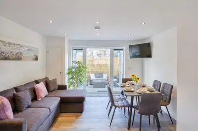 a living room with a couch and a table at 2022 Modern Home In Central Hayle With Parking & EV plug in Hayle