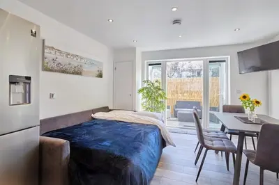 a bedroom with a bed and a table with chairs at 2022 Modern Home In Central Hayle With Parking & EV plug in Hayle