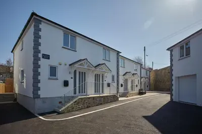 a row of white houses on a street at 2022 Modern Home In Central Hayle With Parking & EV plug in Hayle
