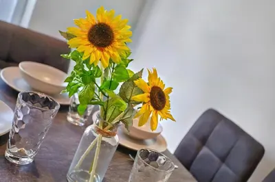 a vase filled with sunflowers sitting on a table at 2022 Modern Home In Central Hayle With Parking & EV plug in Hayle