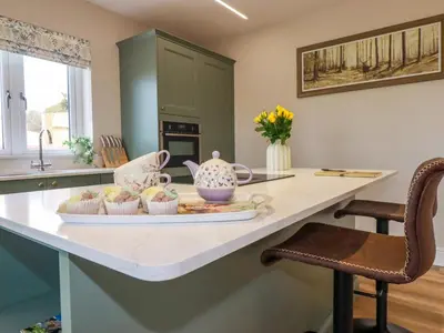 a kitchen counter with a tray of cupcakes on it at Little Hillside in Redruth