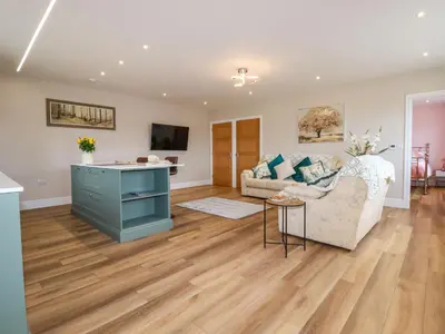 a living room with a couch and a table at Little Hillside in Redruth