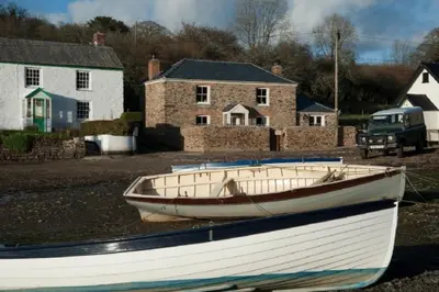 a boat sitting on the ground in front of houses at Riverside in Kea