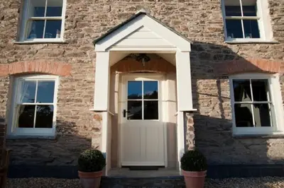 a white door on a brick building with two windows at Riverside in Kea