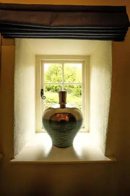 a window with a vase sitting in a window sill at Riverside in Kea