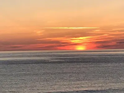 a sunset over a body of water with the ocean at Lovely Shepherds hut near St Ives Cornwall in Gwinear Road Station