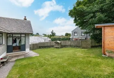 a yard with a house and a fence at Elisa Villa - tranquil retreat 5 mins from the sea in Port Isaac