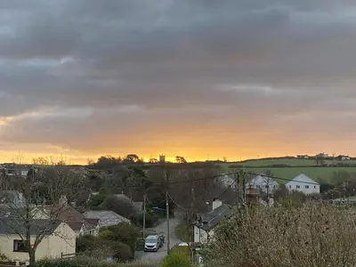 a view of a town with a sunset in the background at Elisa Villa - tranquil retreat 5 mins from the sea in Port Isaac