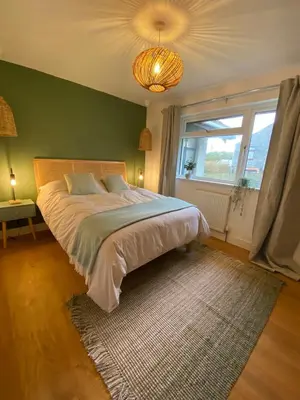 a bedroom with a large bed with a green wall at Elisa Villa - tranquil retreat 5 mins from the sea in Port Isaac