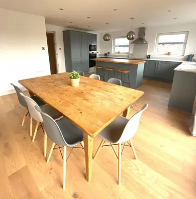 a wooden table and chairs in a kitchen at Elisa Villa - tranquil retreat 5 mins from the sea in Port Isaac