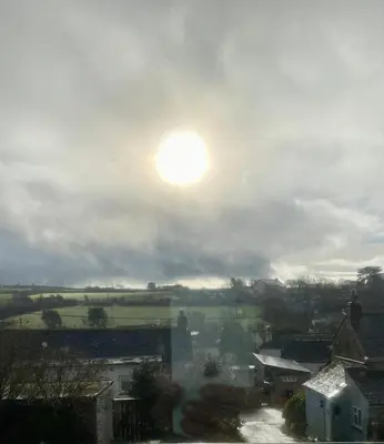 a view of a city with the sun in the sky at Elisa Villa - tranquil retreat 5 mins from the sea in Port Isaac
