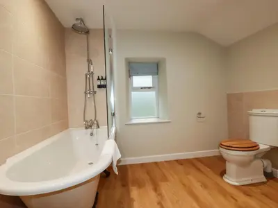 a bathroom with a tub and a toilet at Tretoil Farm House in Bodmin