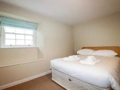 a bedroom with a bed with towels on it at Tretoil Farm House in Bodmin