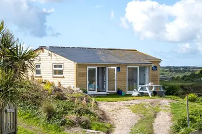 a tiny house on a hill with a gravel driveway at WestHill Beach Chalet, Riviere Towans in Hayle