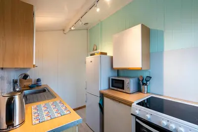 a kitchen with a refrigerator and a microwave at WestHill Beach Chalet, Riviere Towans in Hayle