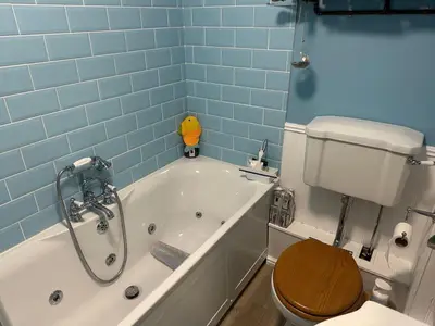 a bathroom with a toilet and a bath tub with a toilet at Penolva Beach Side Apartment in Perranporth