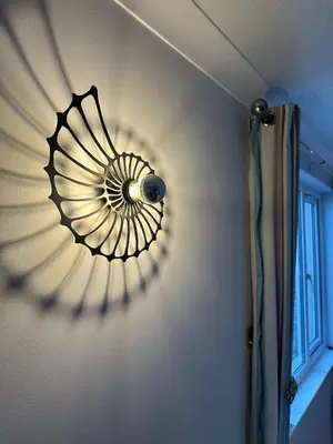 a light fixture on a wall in a room at Penolva Beach Side Apartment in Perranporth
