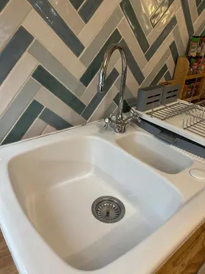 a white sink with a faucet in a kitchen at Penolva Beach Side Apartment in Perranporth