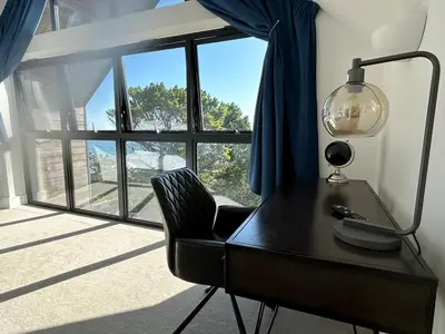 a desk with a lamp and a chair in front of a window at Perpetual House St Ives Cornwall in St Ives