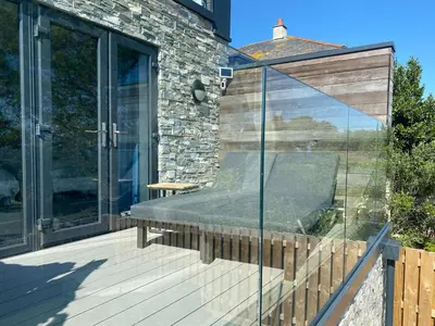 a glass patio with a bench on a deck at Perpetual House St Ives Cornwall in St Ives
