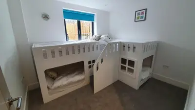 two white bunk beds in a room with a window at Perpetual House St Ives Cornwall in St Ives