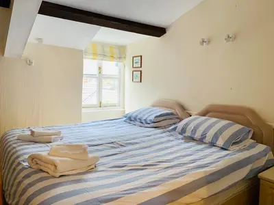 a bedroom with a bed with towels on it at Maypole Cottages - No 12 Broad Street in Padstow
