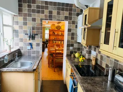 a kitchen with a sink and a dining room at Maypole Cottages - No 12 Broad Street in Padstow