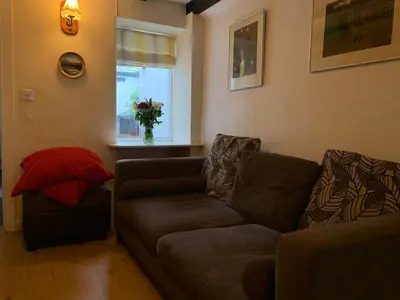 a living room with a couch and a window at Maypole Cottages - No 12 Broad Street in Padstow
