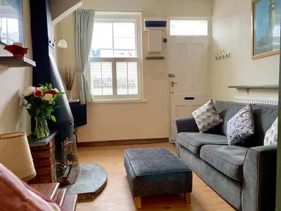 a living room with a couch and a window at Maypole Cottages -5 Mill Road in Padstow