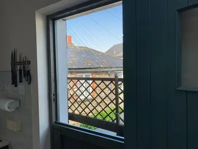 a window in a bathroom with a view of a balcony at - Maypole Cottages - No 2 Mill Road in Padstow