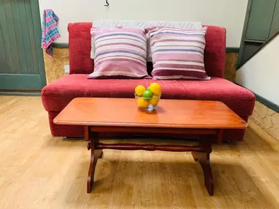 a table with a bowl of fruit on top of a couch at - Maypole Cottages - No 2 Mill Road in Padstow