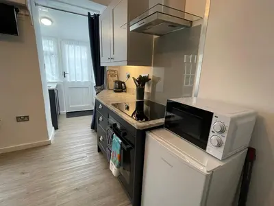 a kitchen with a stove and a microwave at Cosy Cottage, Mevagissey in Mevagissey